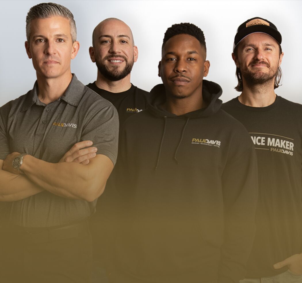 Paul Davis Restoration team members posing in branded shirts and hoodie